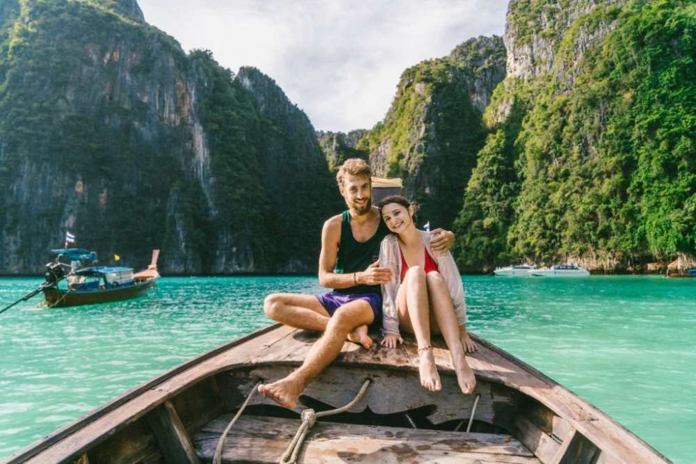 Un couple est assis sur un bateau pour visiter la baie de Krabi, en Thaïlande.
